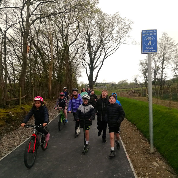 Comins Coch Primary School pupils walking, cycling and scooting on the new shared use path to Comins Coch